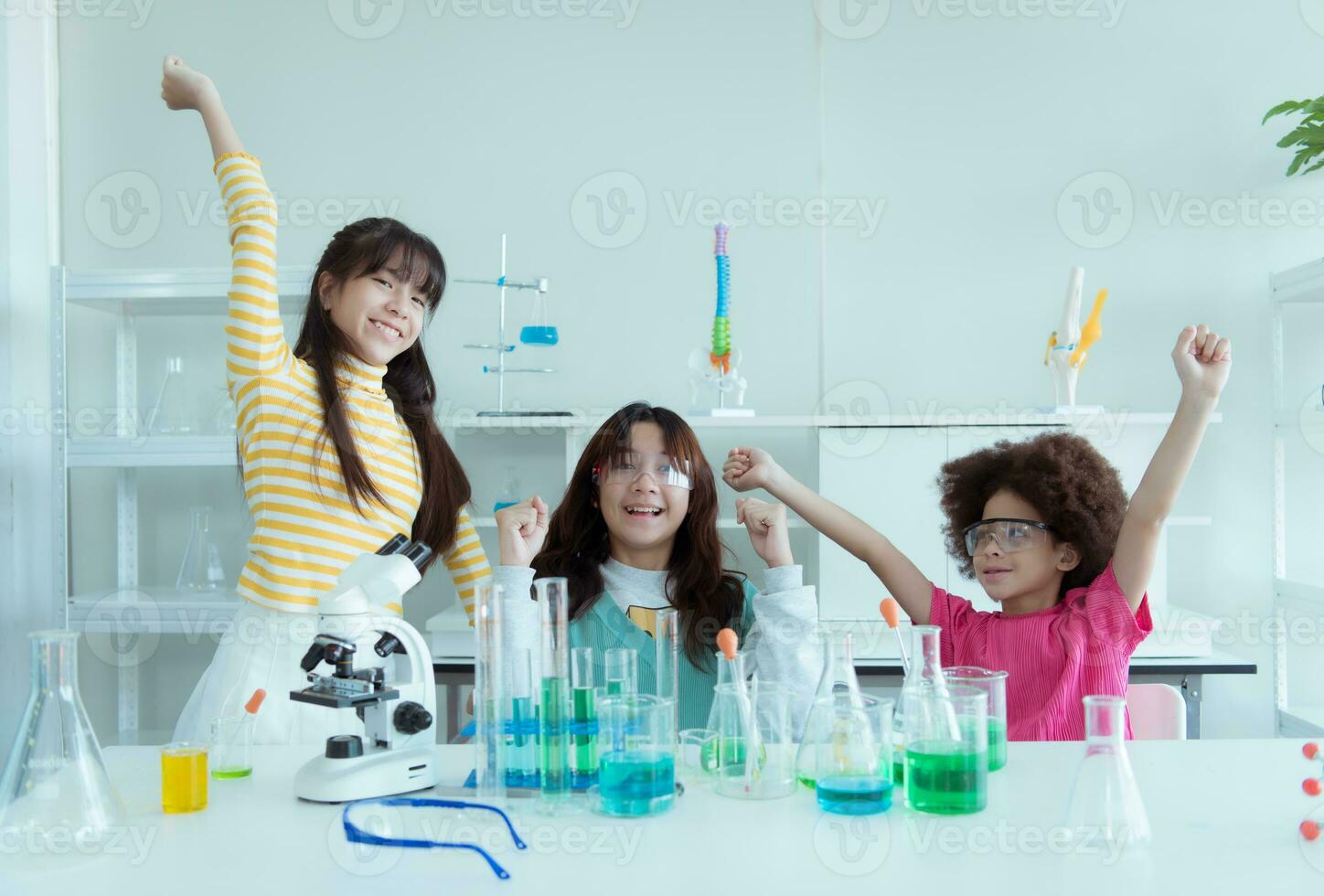 In the science classroom, an Asian child scientist experimenting with scientific formulas with chemicals photo