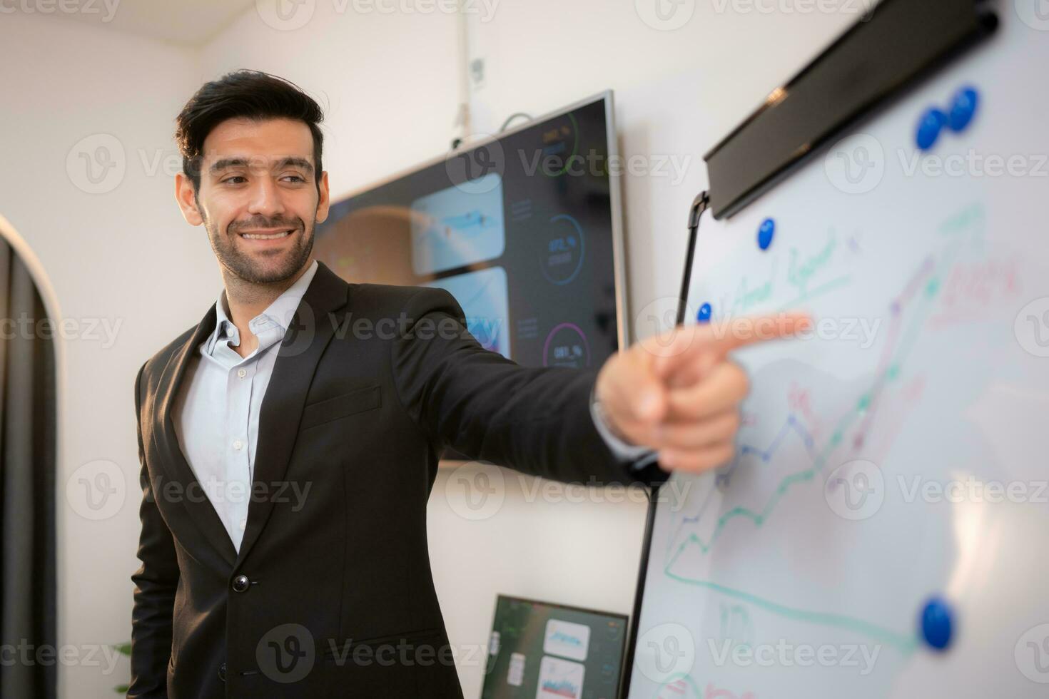 Businessman pointing on flip chart in office, focus on hand. photo