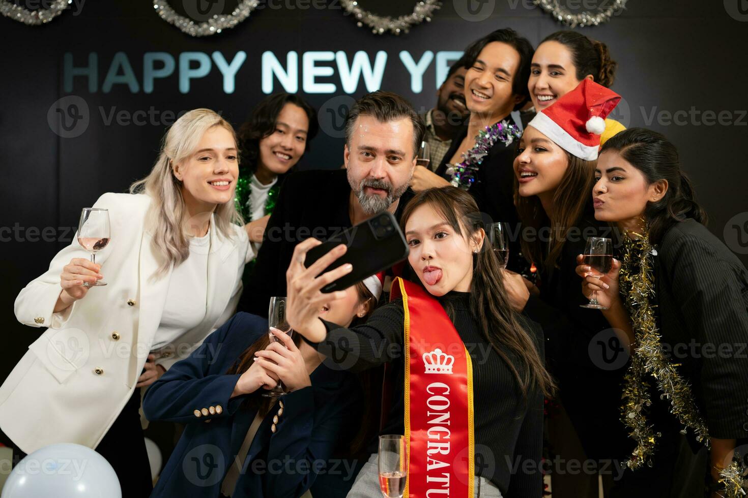 un grupo de joven personas tomar selfies con su teléfono inteligente a un nuevo años víspera fiesta. foto