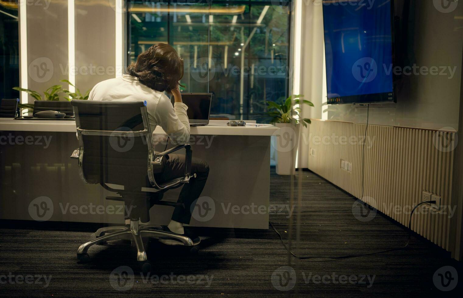 Side view of young businessman sitting at desk in office and looking away, Business disappointment concept photo
