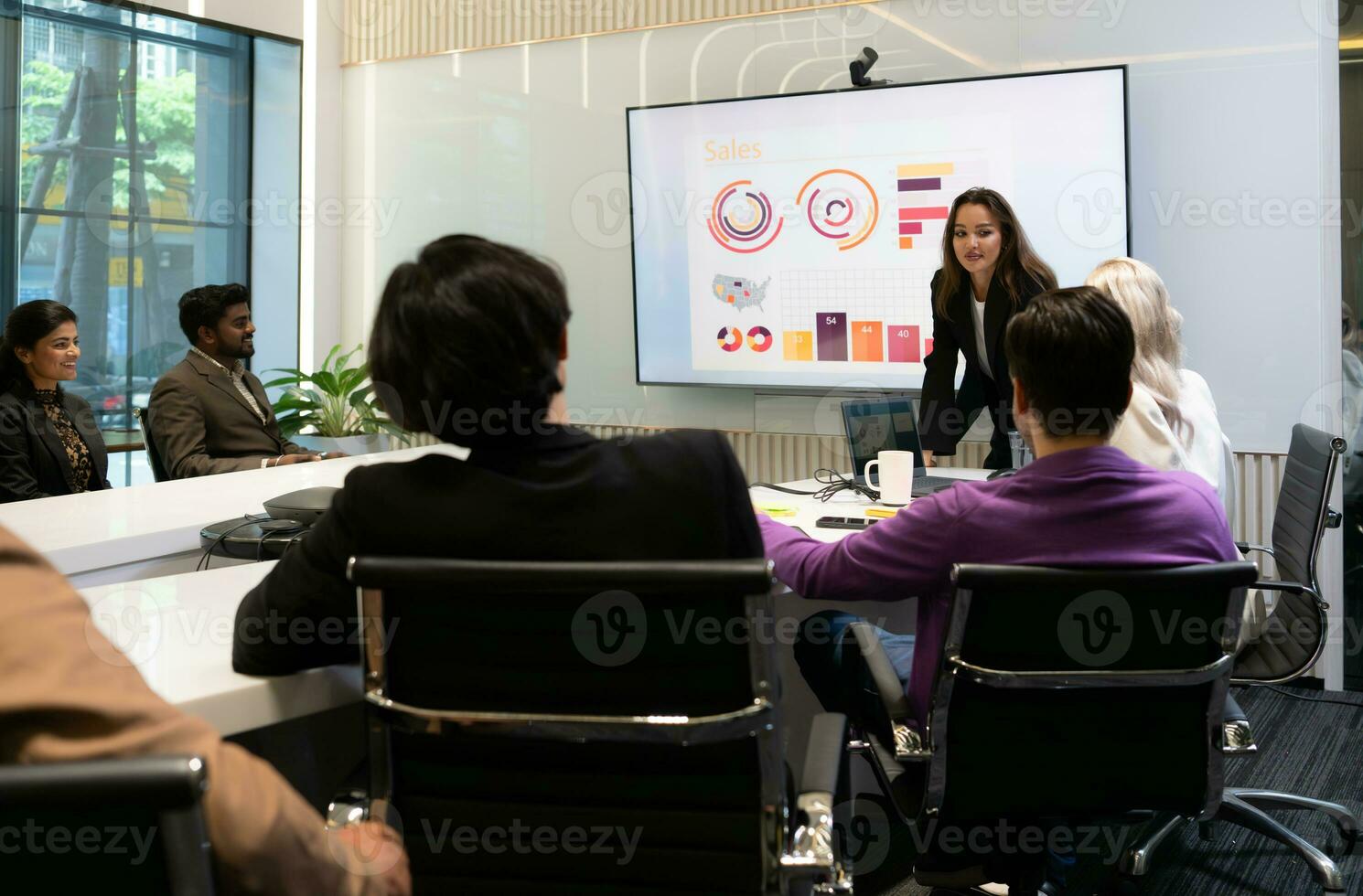 Businesswoman giving presentation to a group of people in a conference room photo