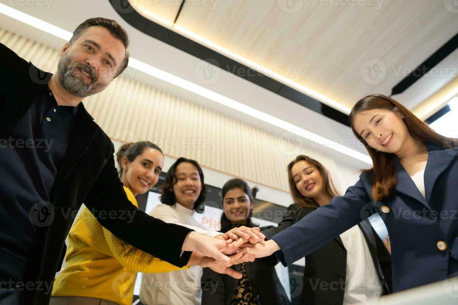 Business people putting their hands together as a symbol of unity and teamwork photo