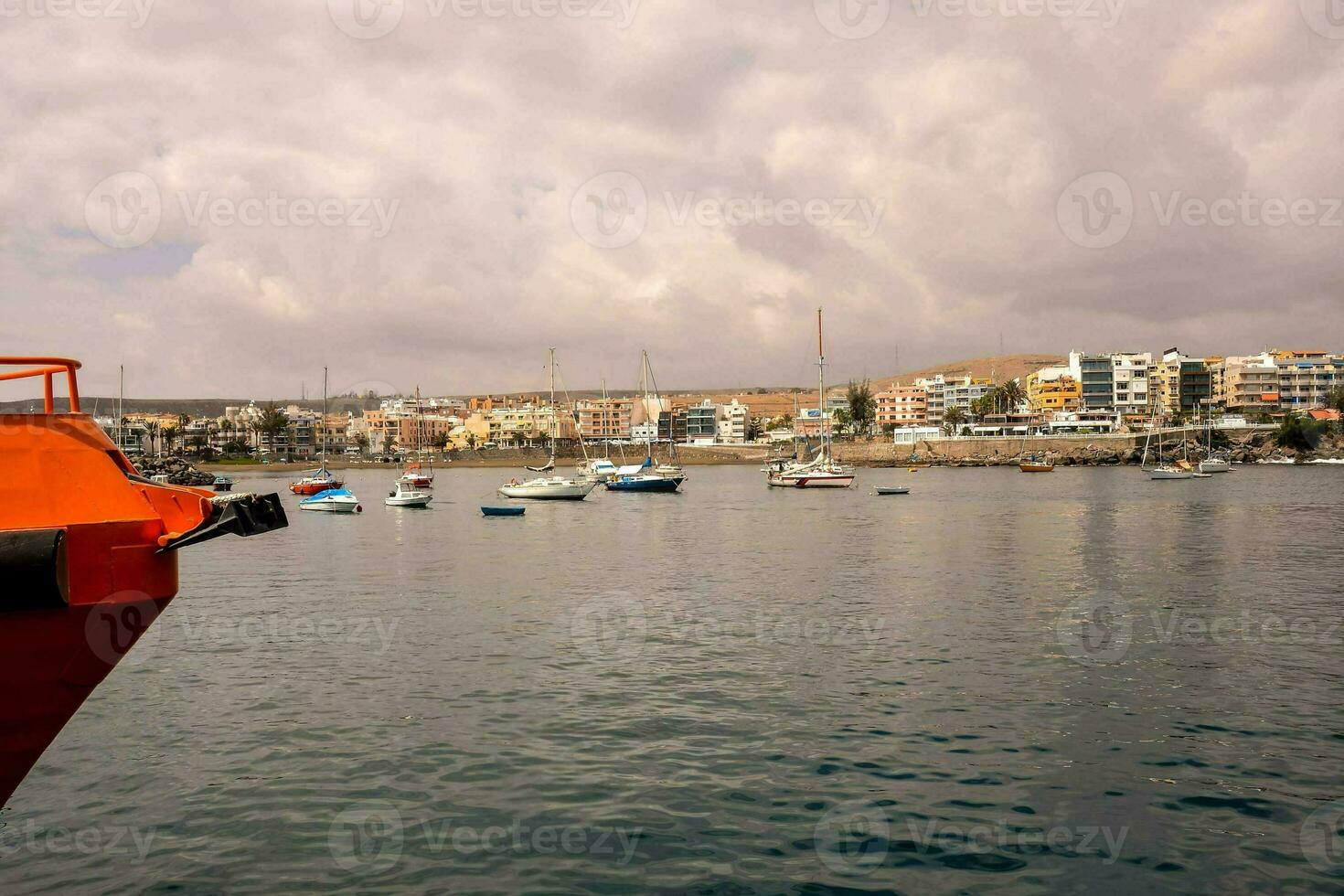 a boat is docked in the water with a city in the background photo