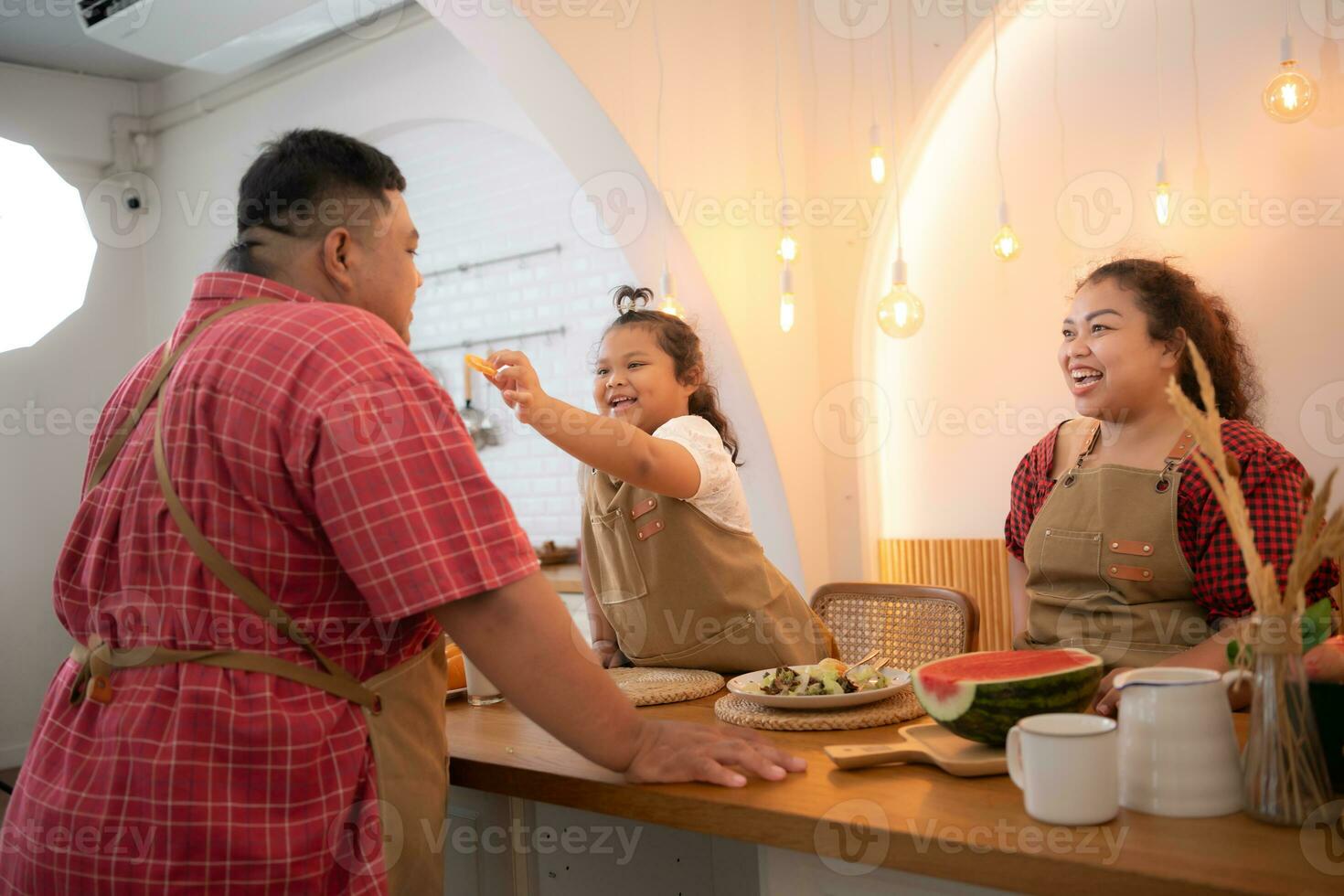 un talla extra familia con un padre vistiendo un protésico pierna, comer juntos después Cocinando y hija bebidas Leche para salud en el comida habitación de el casa foto