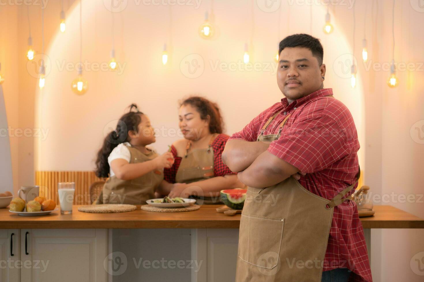 A plus-size family with a father wearing a prosthetic leg, Eat together after cooking and daughter drinks milk for health in the dining room of the house photo