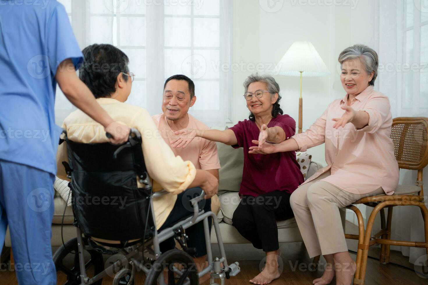 Close-up of senior woman in wheelchair with her caregiver in background and elderly friends are waiting to welcome photo