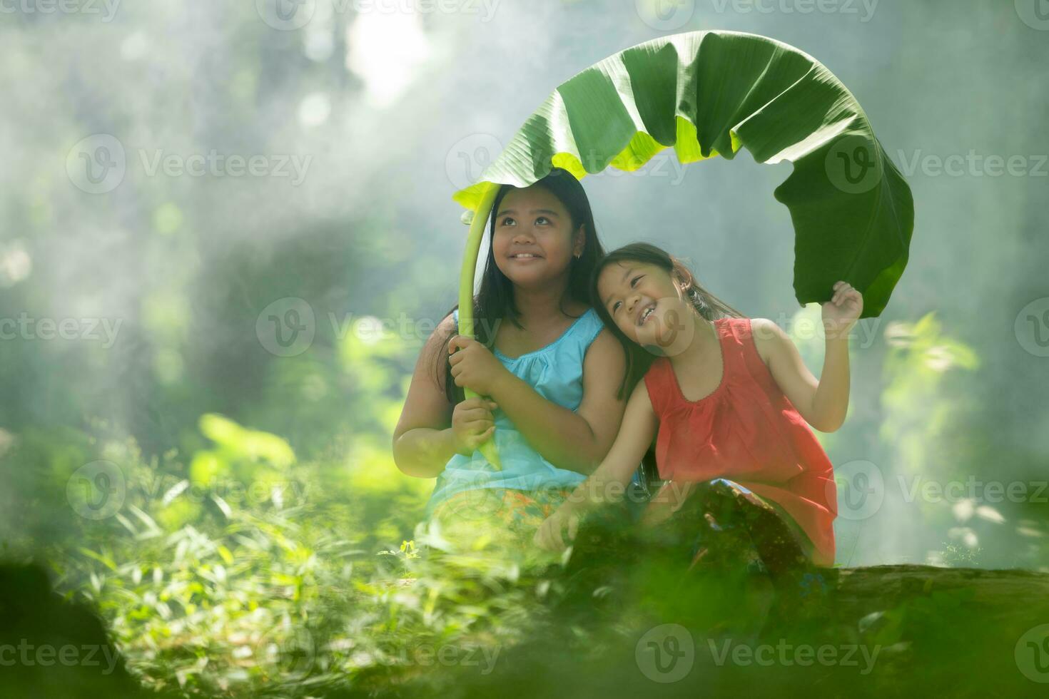 Two girls Asian women with traditional clothing stand had fun playing together in the rainforest. photo