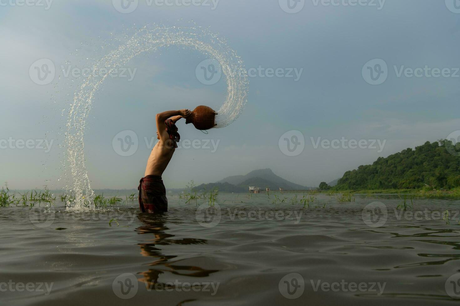 Fishermen using traditional fishing equipment After catching fish, clean up and play in the water. photo