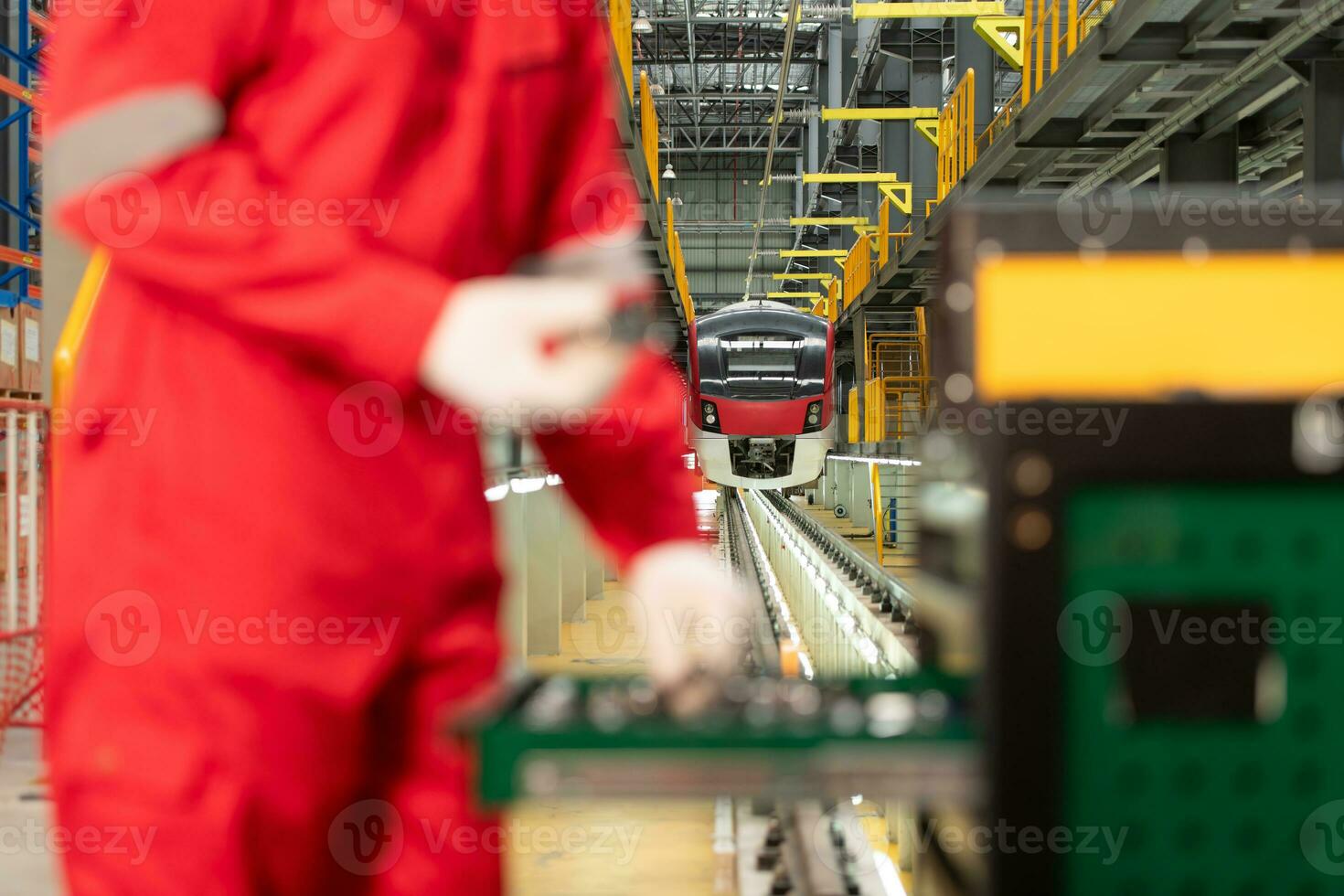 Picture of engineer using repair tools of the electric train industry There is an electric train in the train repair factory as the background image. photo