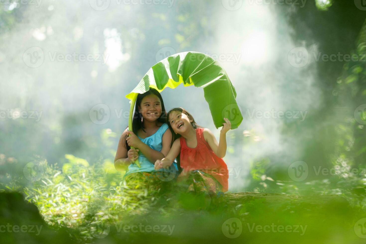 Two girls Asian women with traditional clothing stand had fun playing together in the rainforest. photo