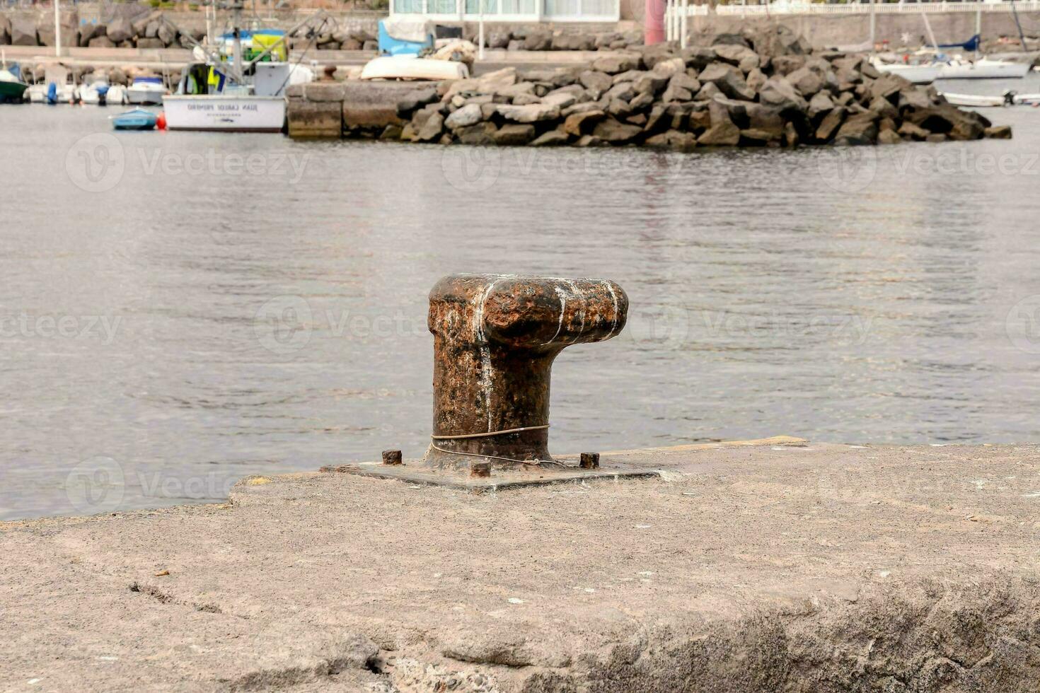 a rusty metal pipe sitting on the edge of a pier photo