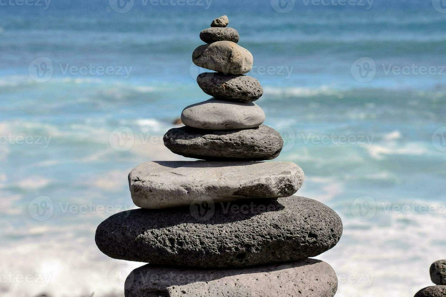 a stack of rocks by the ocean photo