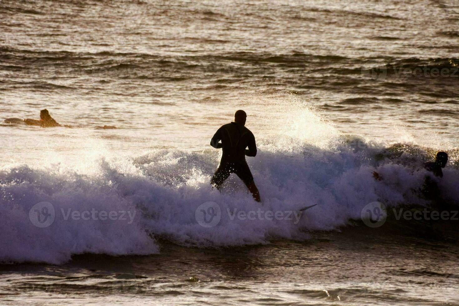 a surfer riding a wave in the ocean photo