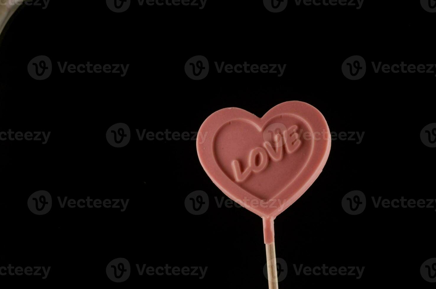a pink heart shaped lollipop with the word love written on it photo