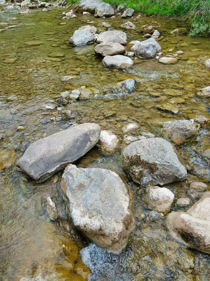 rocks in a river with water flowing over them photo