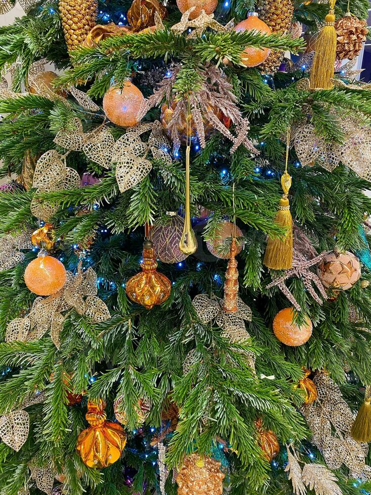 Decorated Christmas tree with orange, pink and golden toys photo