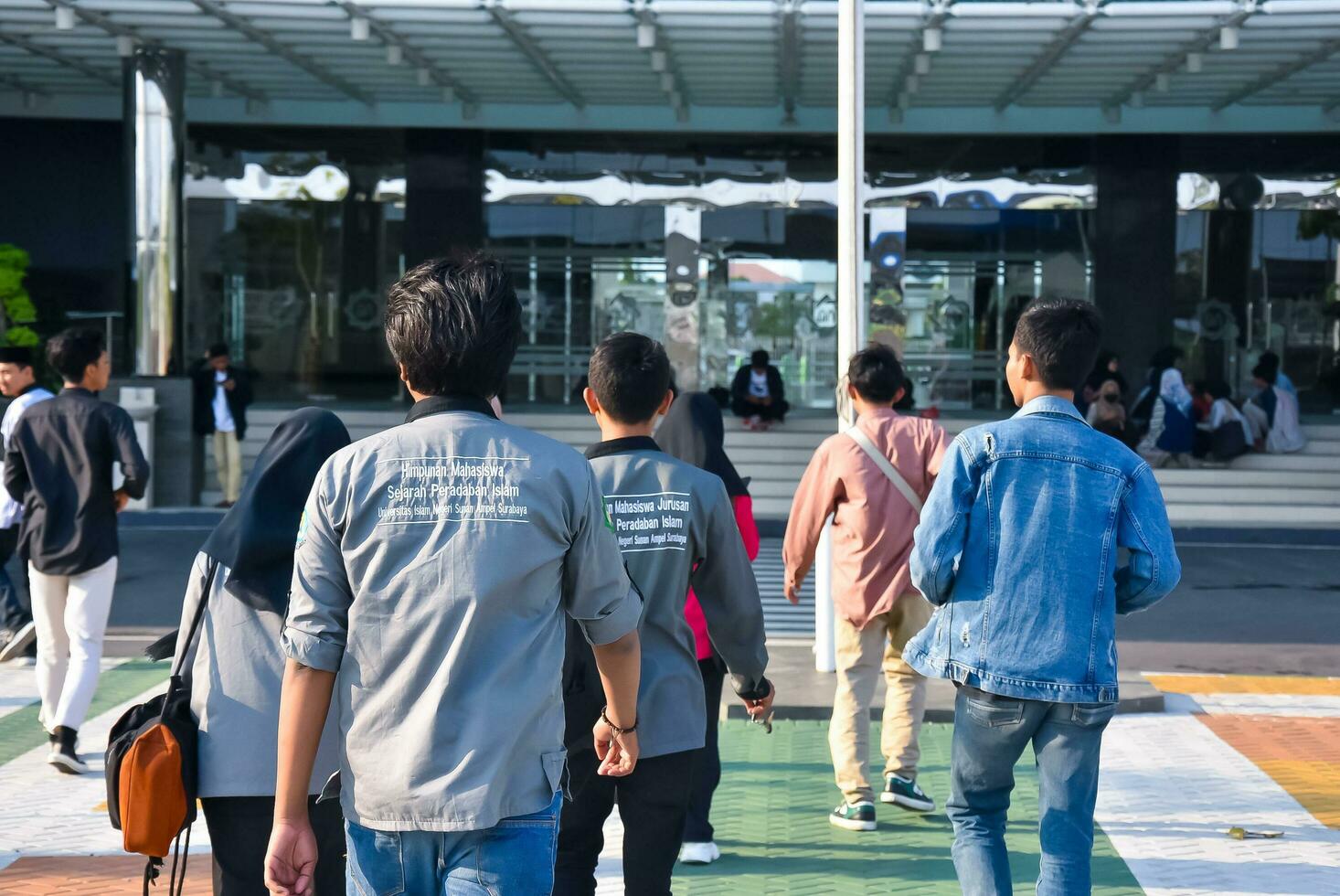 Surabaya, Indonesia - 20-08-2023. a group of young people are walking around a Campus and school, enjoying the weekend with friends photo