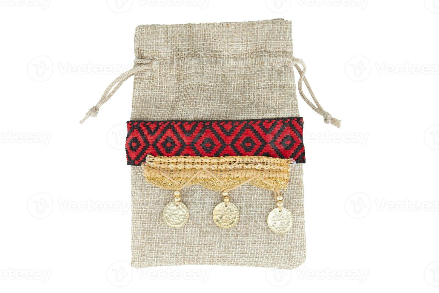 Burlap gift bag with golden coins isolated on white background photo