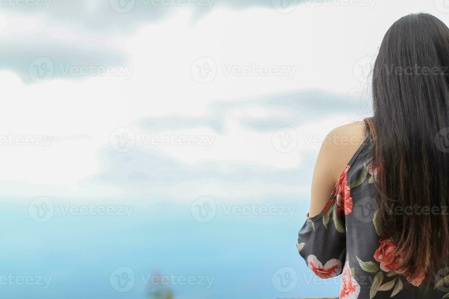 young female tourist is walking and admiring winter nature scenery of Northern Thailand. background of young Asian tourist standing on mountain and against  background of a bright blue sky in winter. photo