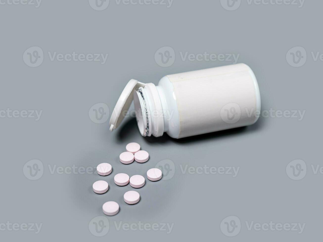 Pills spilling out of pill bottle white  pills  Medicines and prescription pills flat lay background. White medical pills and tablets spilling out of a drug bottle.Copy space for text photo