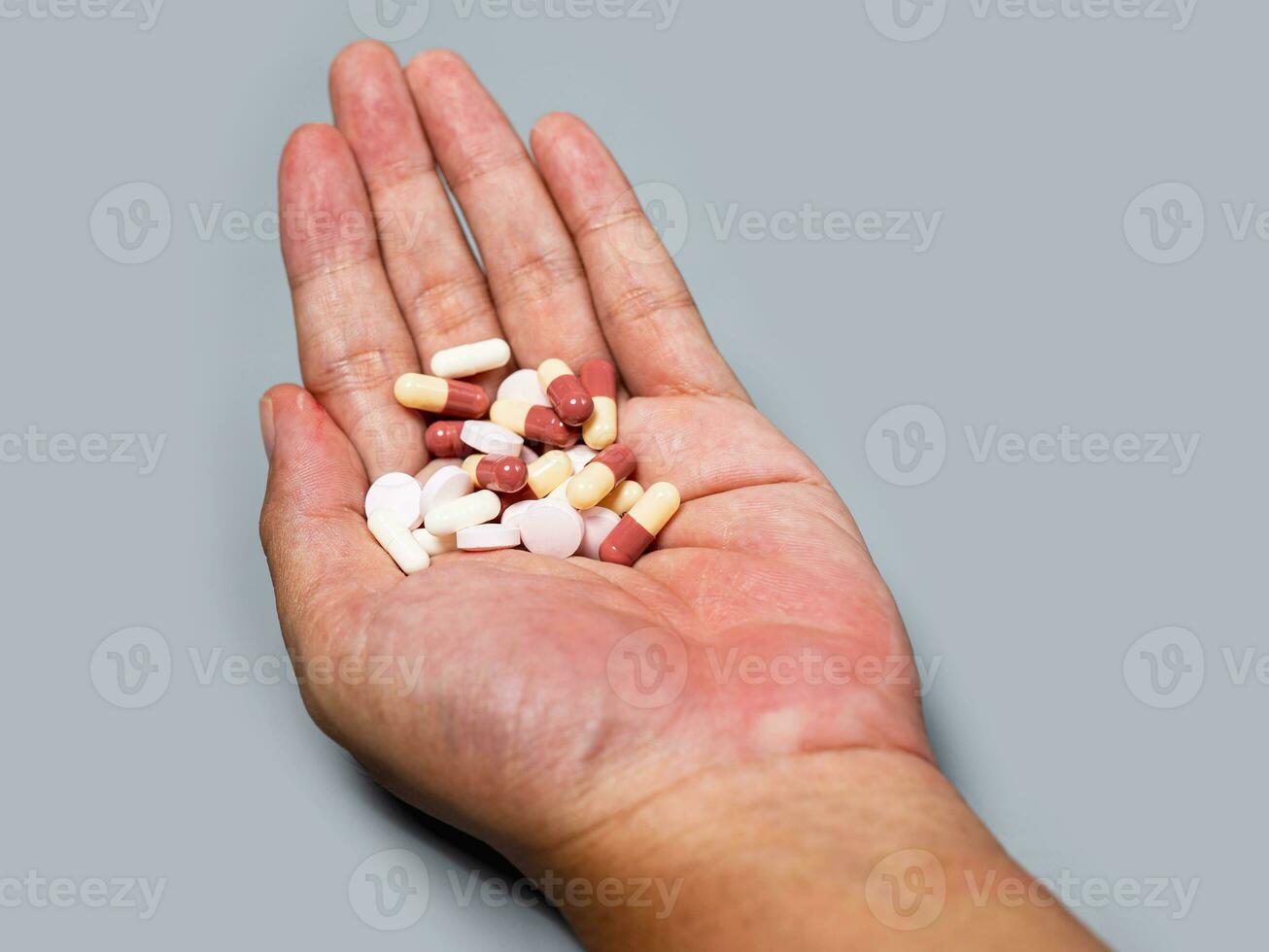 hand pouring capsules from medication take pharmaceutical healthcare treatment concept, close up view Colorful pills and medicines in the hand photo