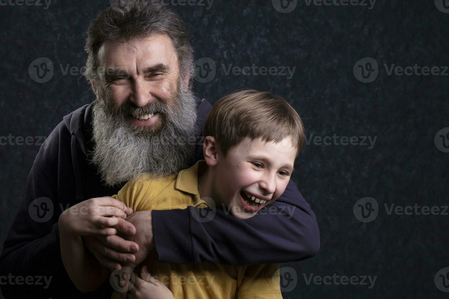 Portrait of a happy grandfather with a beard and grandson on a black background. photo