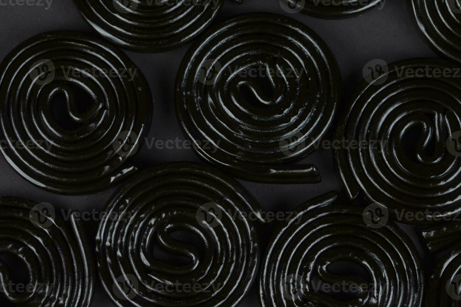 Spiral black background. Licorice candy in the form of a spiral close-up. photo