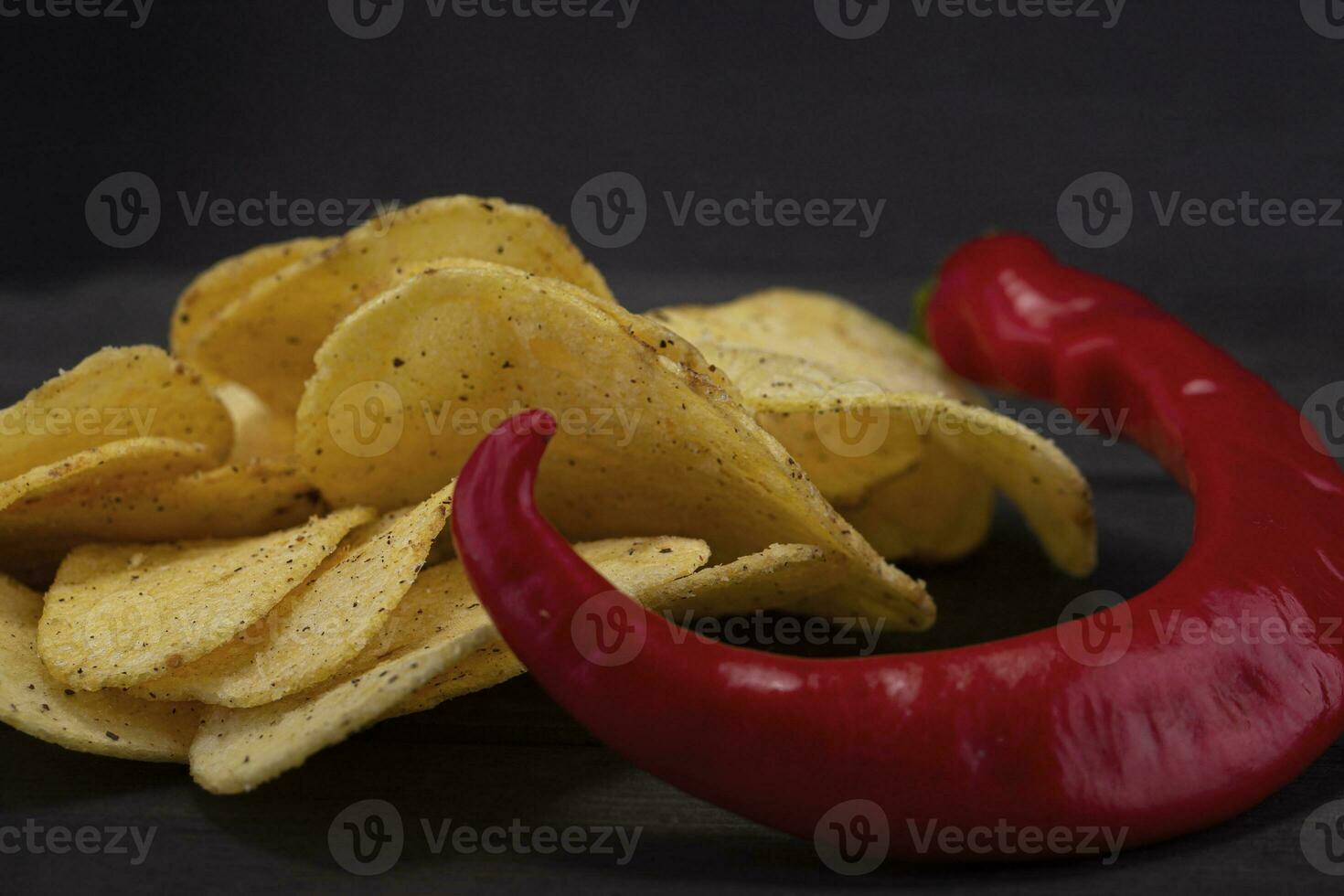 Chips with red pepper on a gray background close-up. photo