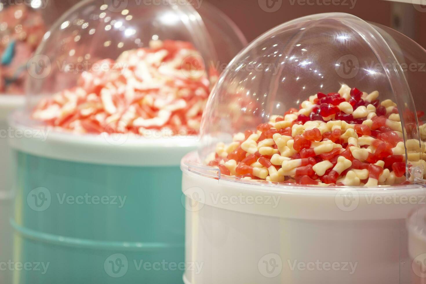 Jelly candies in containers in a store. Large selection of sweets in different colors. Sale of sweets. photo