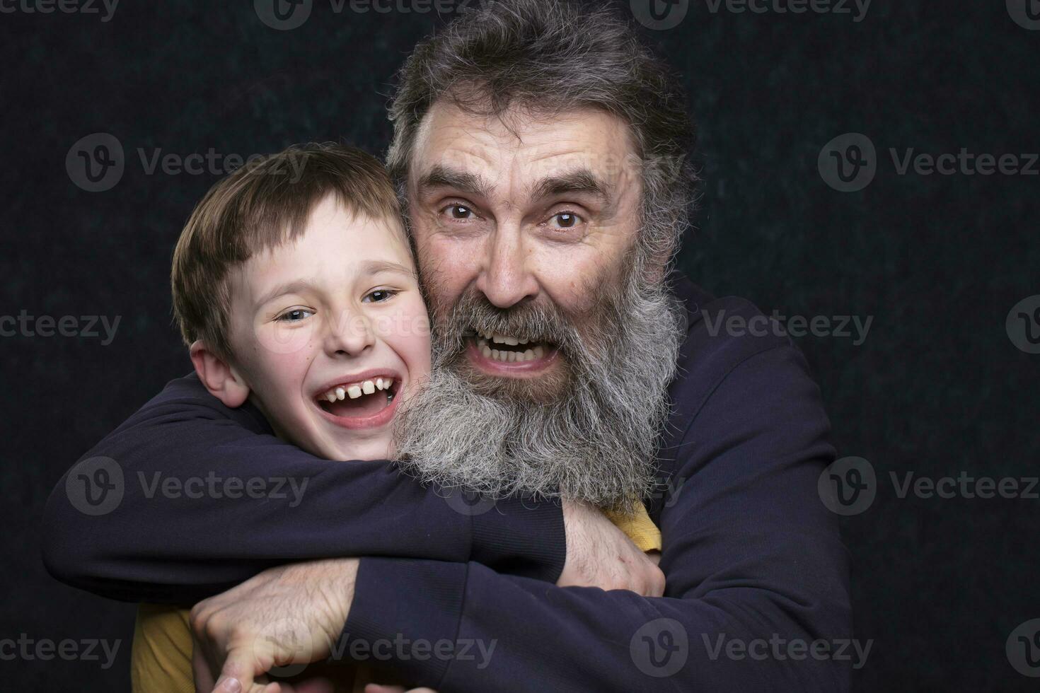 Portrait of a happy grandfather with a beard and grandson on a black background. photo