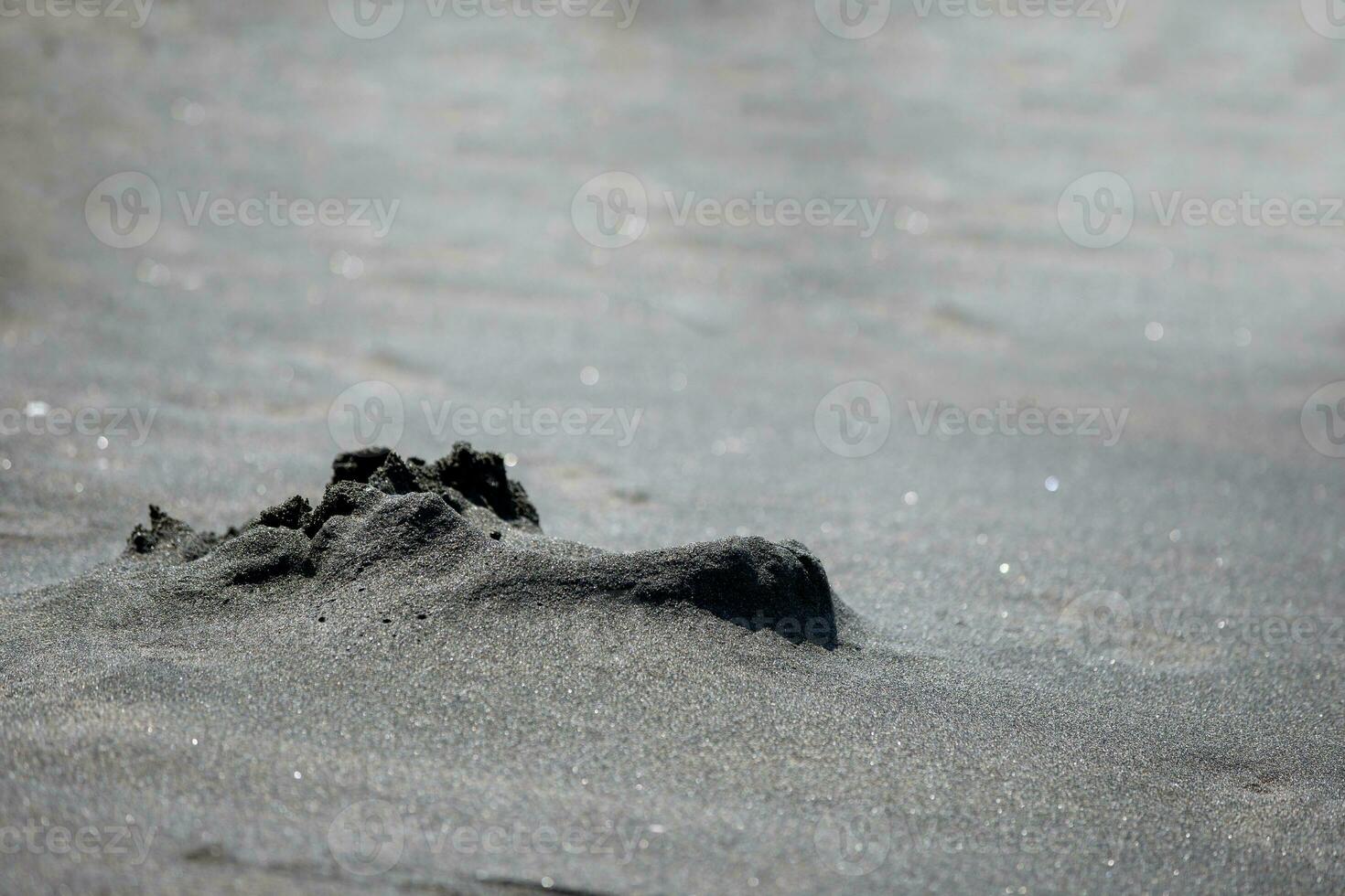 Black magic sand close-up.Sand texture wet photo