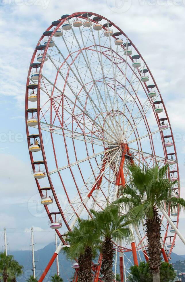 Retro ferris wheel carousel on the background of the sky in emerald toning. photo