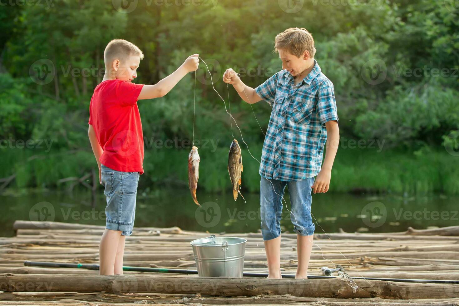 Two boys of a friend on a fishing trip are considering the catch. photo