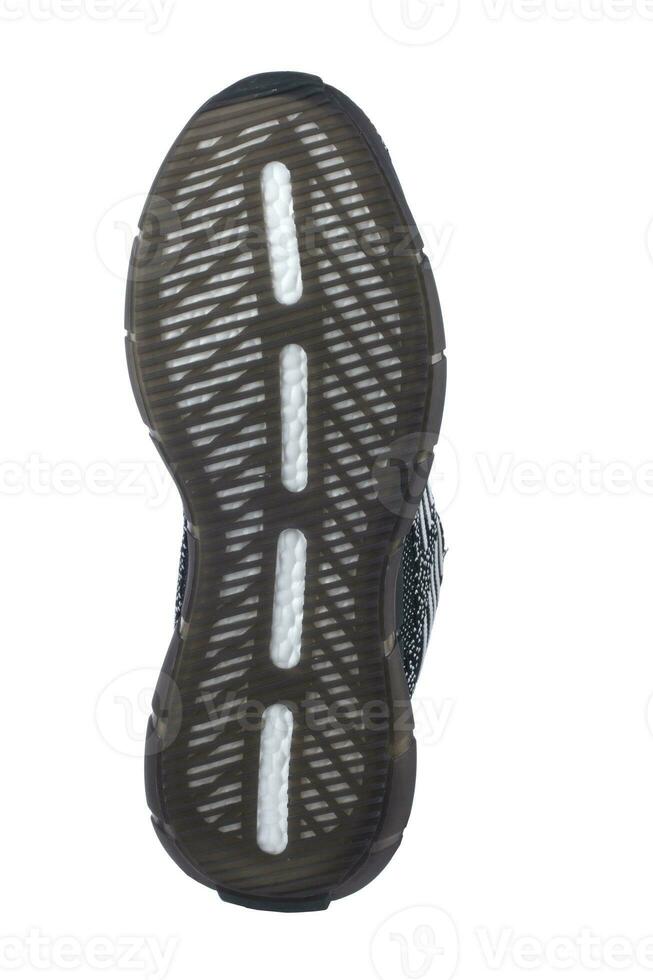 negro único zapatilla de deporte con gris toques en un blanco antecedentes. foto