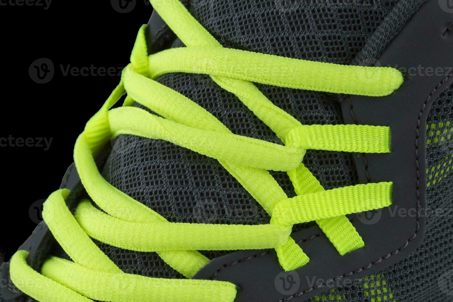 Fragment of black sneaker with green laces close up. Sneaker texture photo