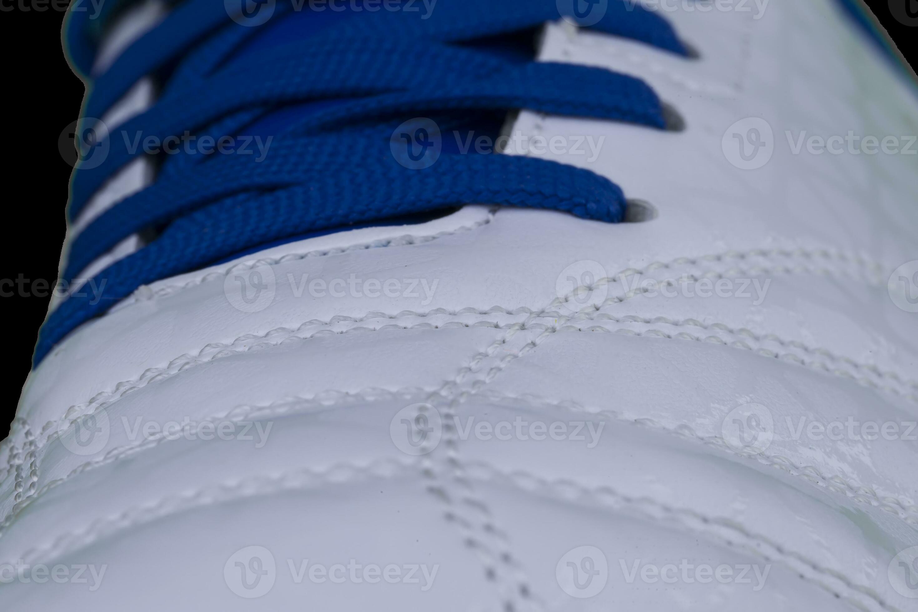 A fragment of a white sneaker with blue laces close up. Sneaker texture