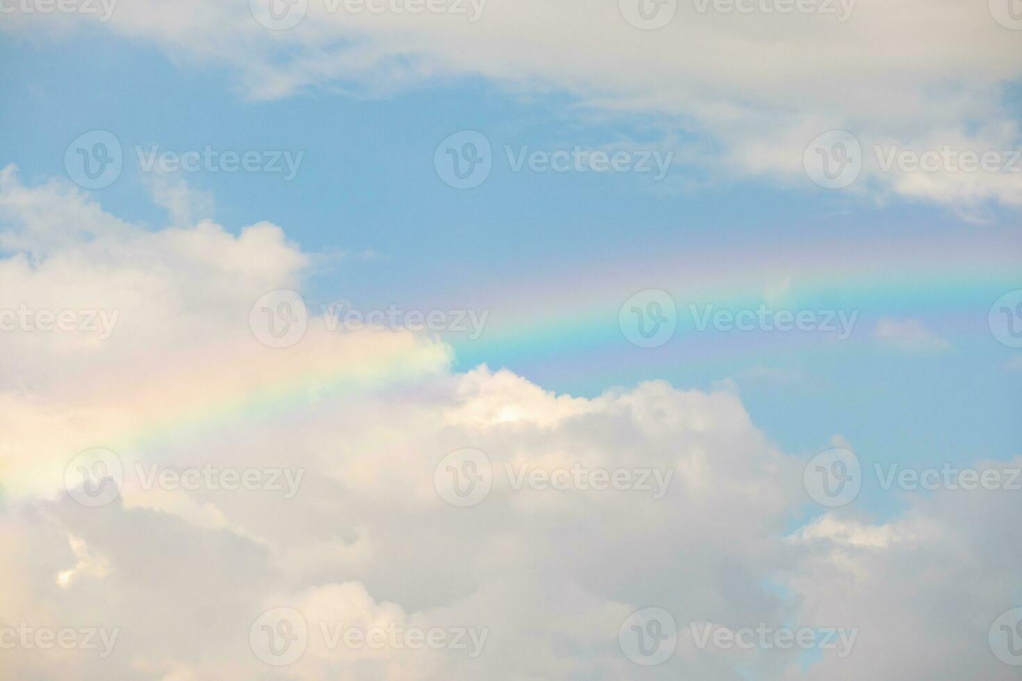Beautiful rainbow with clouds and blue sky photo
