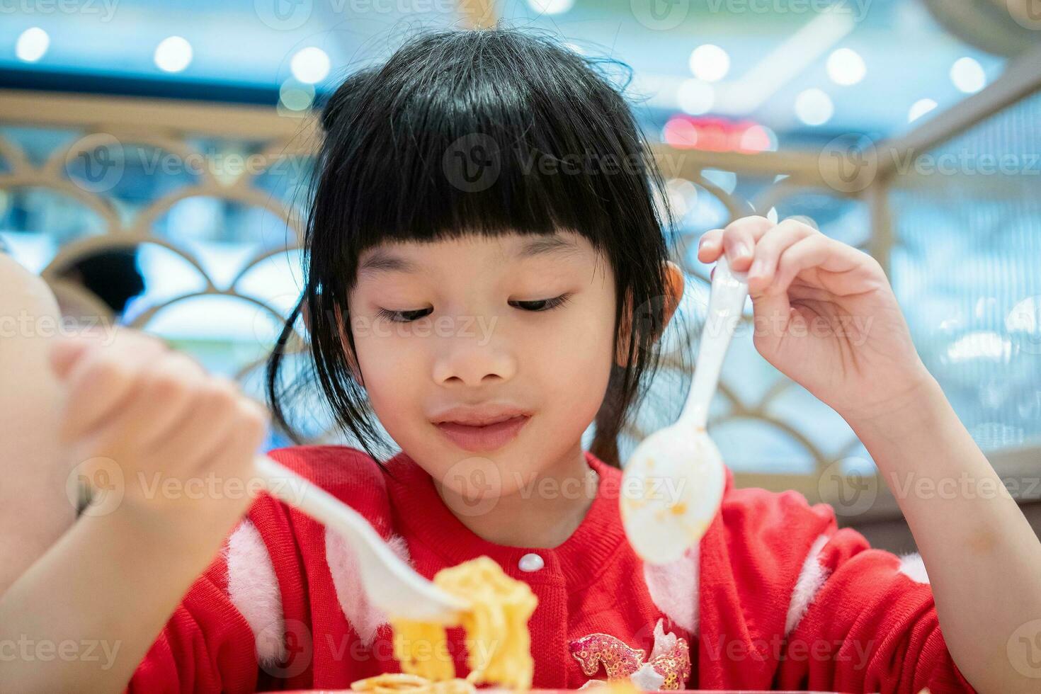 linda pequeño asiático niño niña comiendo comida foto