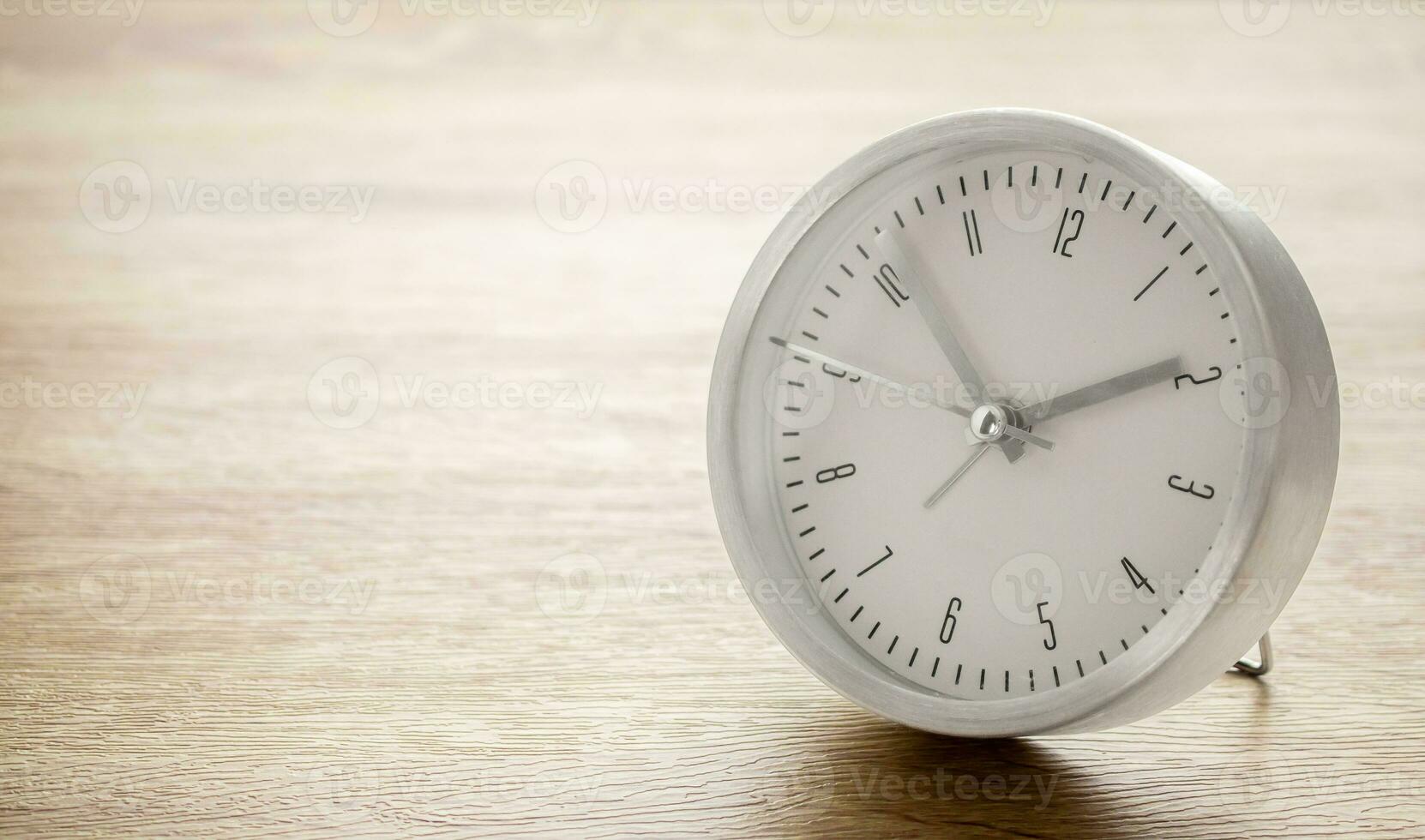 Silver alarm clock on wood table background photo