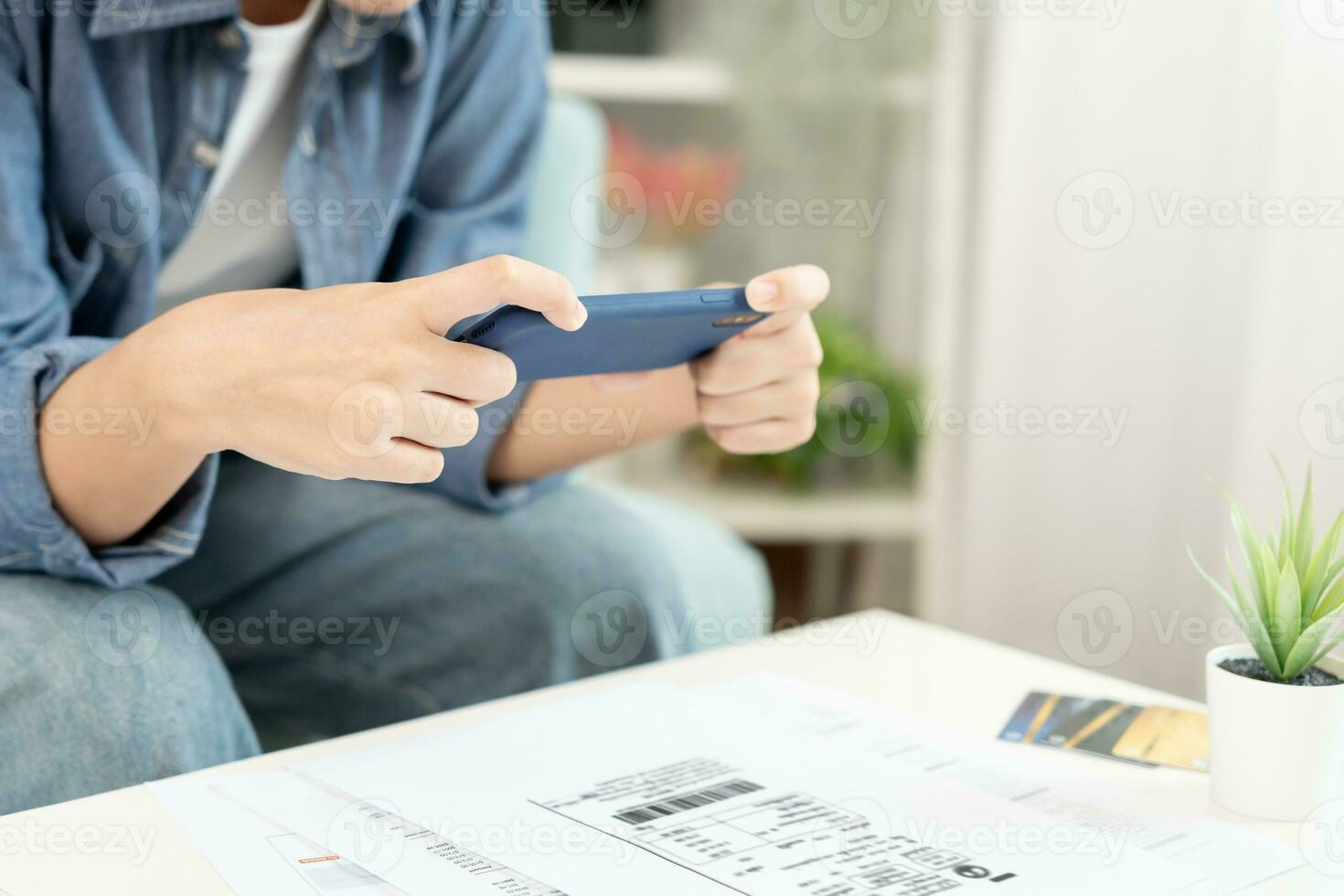 woman use phone scan barcode or QR codes to pay credit card bill after receiving document invoice. payment, receive, paying electricity, digital payments, technology, scanning, financial transactions photo