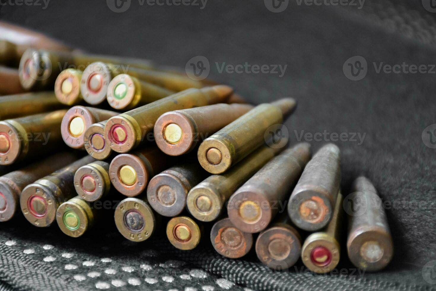 Old sniper bullets pile on dark background, soft focus, new edited, concept for shooting sports and training to protect human life and property around the world. photo