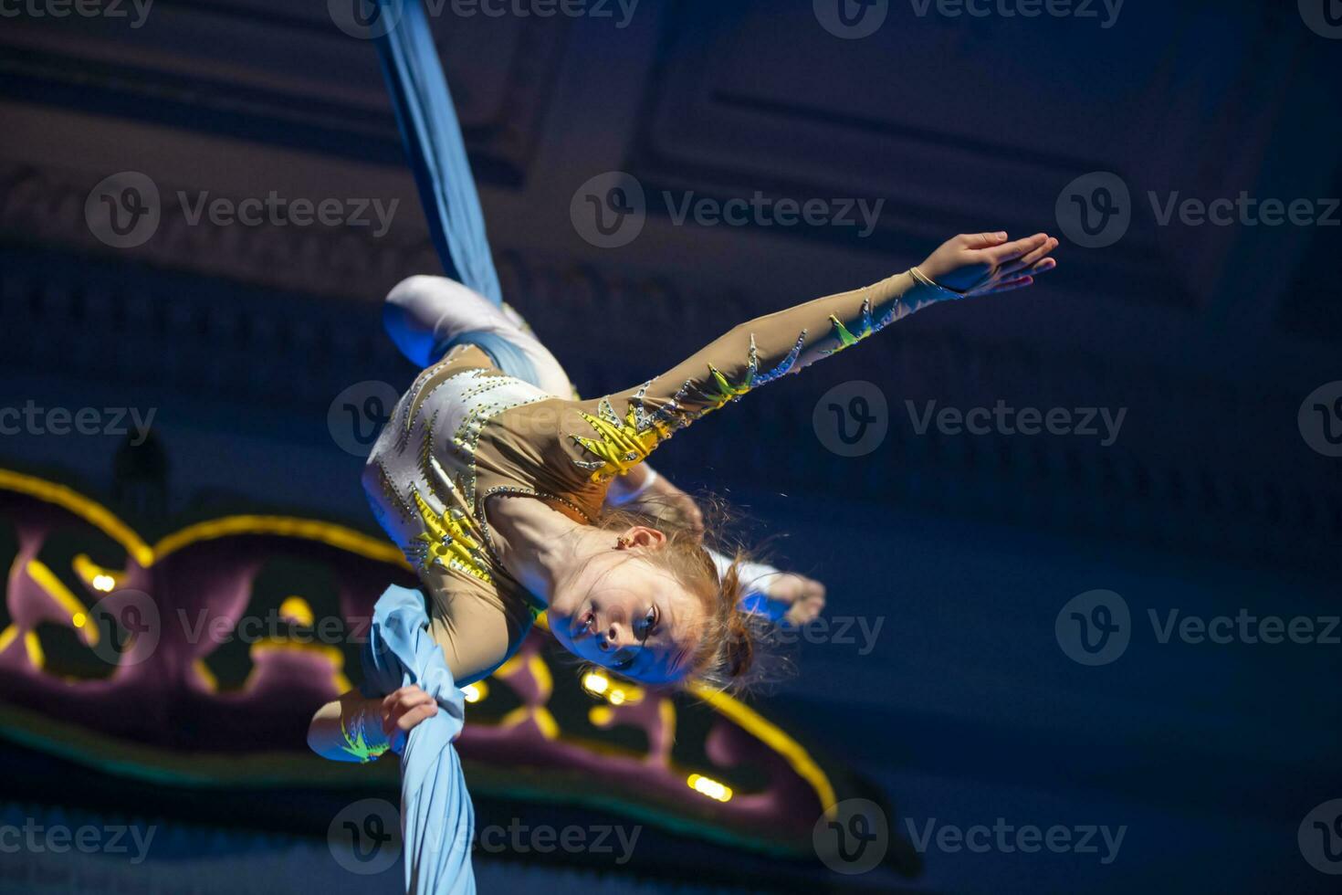 The girl performs acrobatic numbers on the canvases. A small circus artist performs on the canvases of acrobats. Child perform acrobatic elements in the air photo