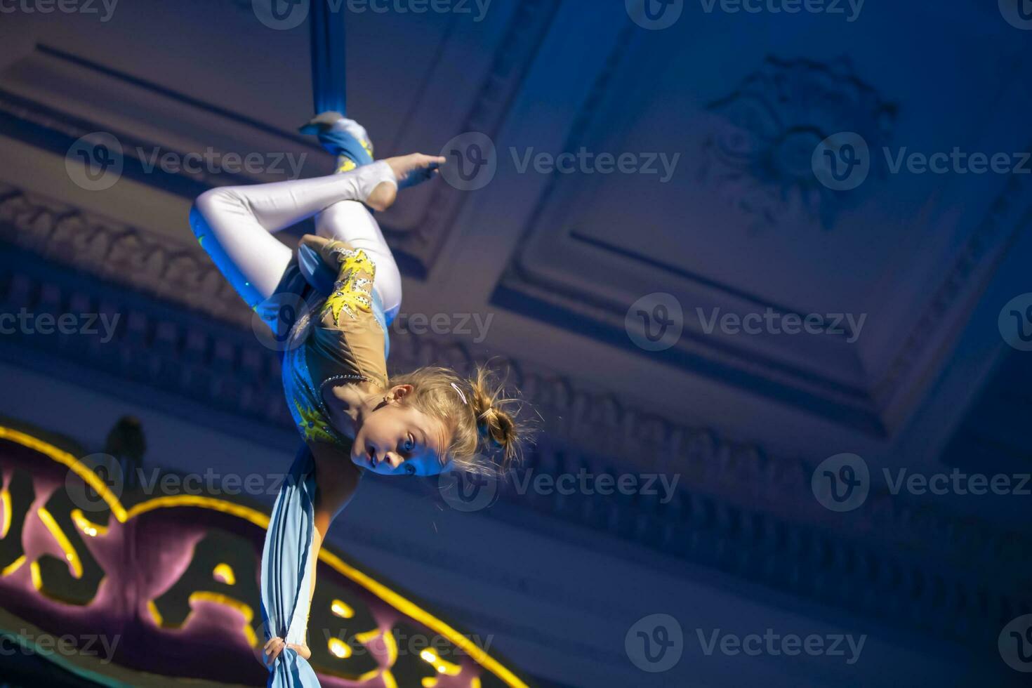 The girl performs acrobatic numbers on the canvases. A small circus artist performs on the canvases of acrobats. Child perform acrobatic elements in the air photo