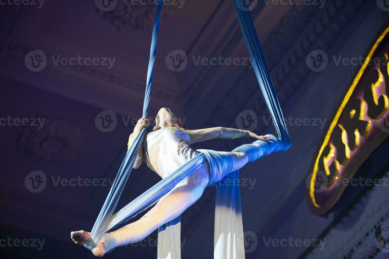 The girl performs acrobatic numbers on the canvases. A small circus artist performs on the canvases of acrobats. Child perform acrobatic elements in the air photo