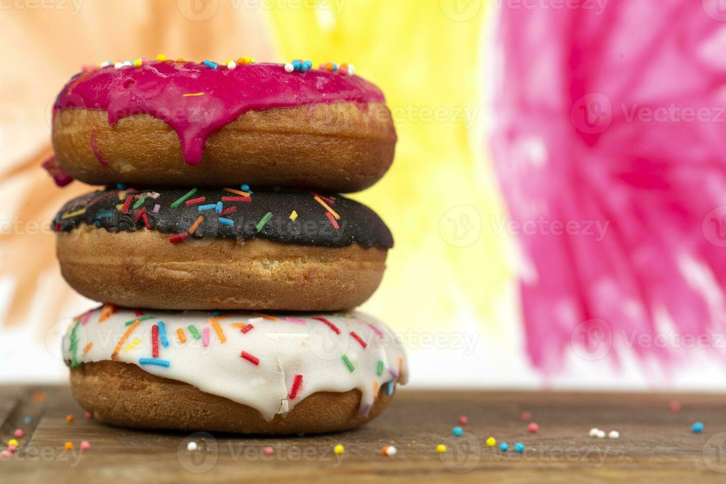 Creative sweet food. A stack of glazed colorful assorted donuts on a bright watercolor painted background. photo