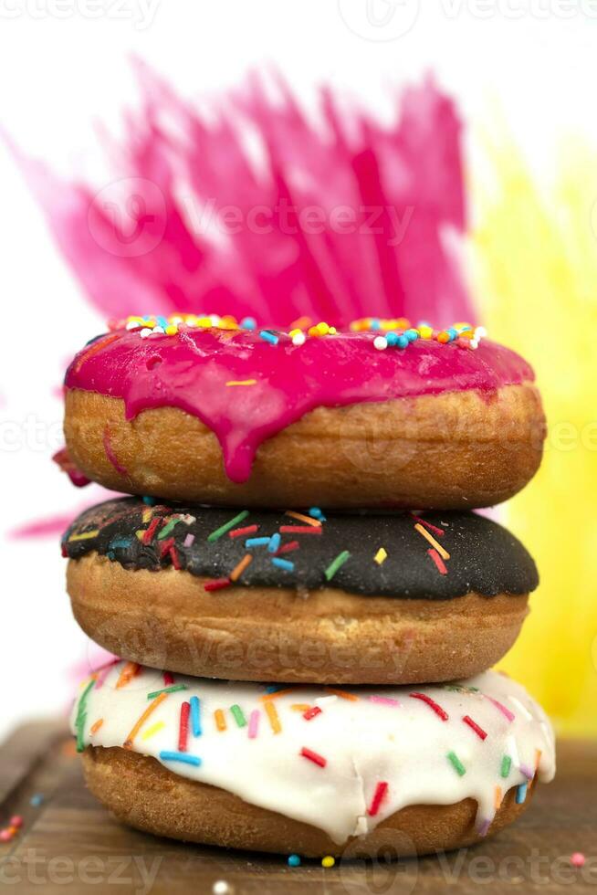 Creative sweet food. A stack of glazed colorful assorted donuts on a bright watercolor painted background. photo