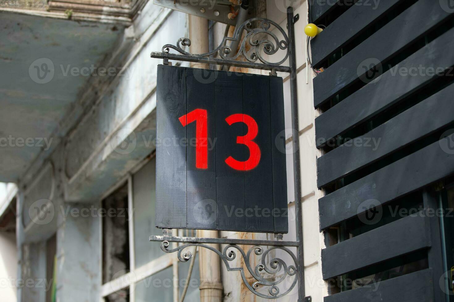 House number thirteen is written in red paint on a black background. Baker's dozen. photo