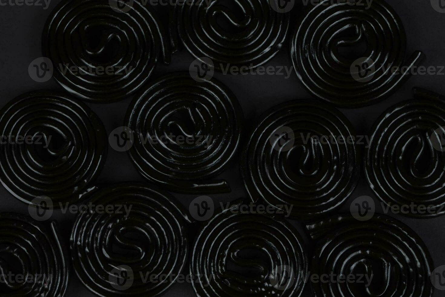 Spiral black background. Licorice candy in the form of a spiral close-up. photo