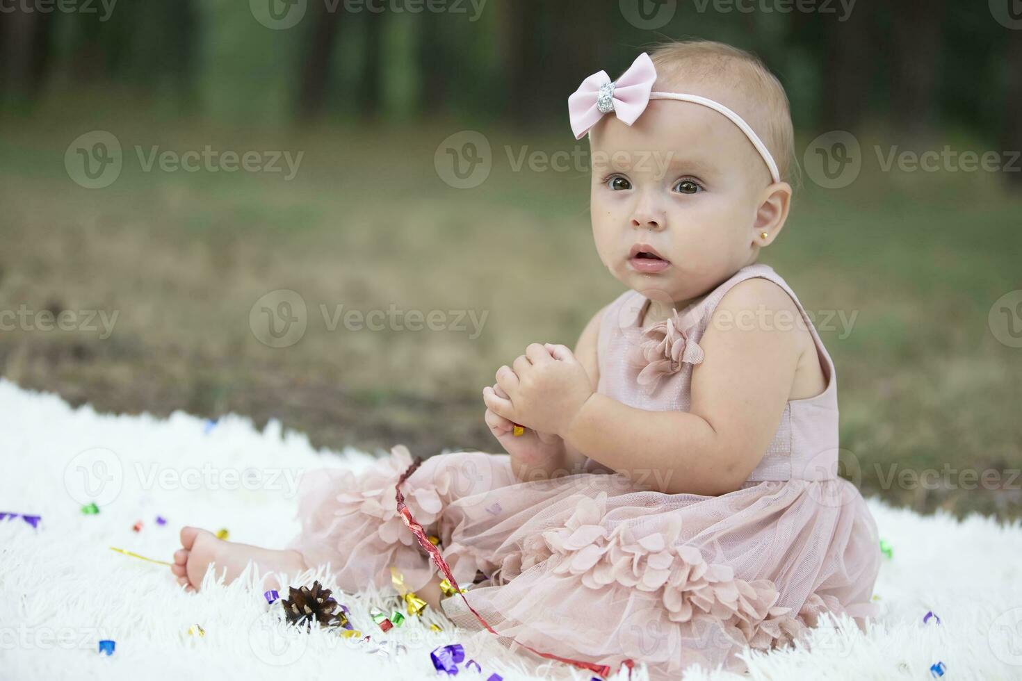 A beautiful little girl on a walk in a summer park. One year old child. Sweet baby. photo