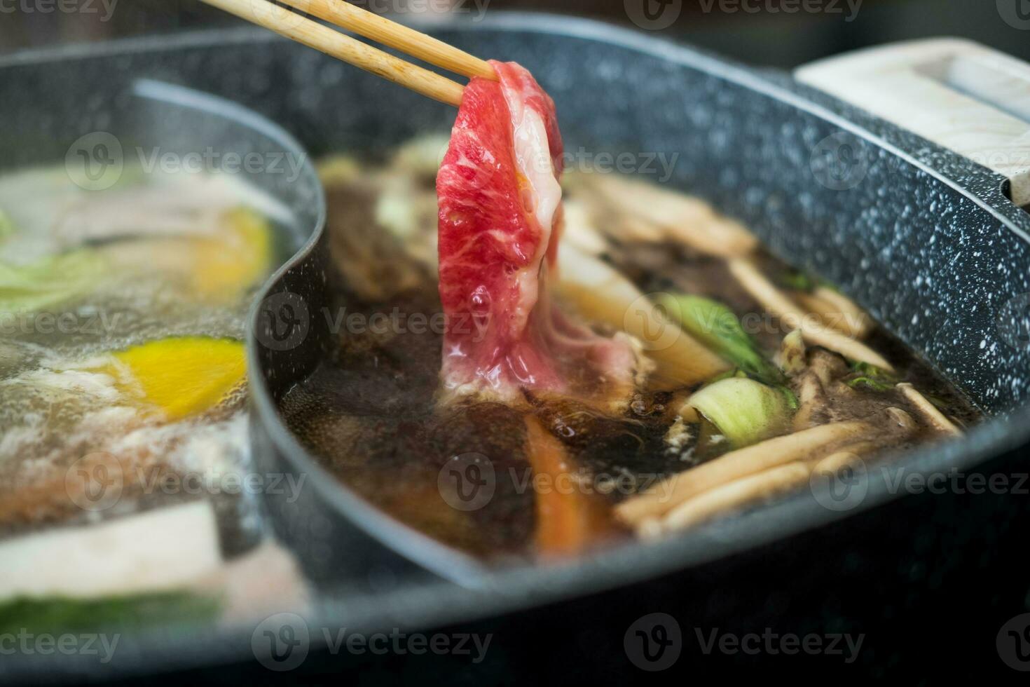 crudo carne de vaca rebanada en madera palillos para japonés Sukiyaki o caliente maceta foto